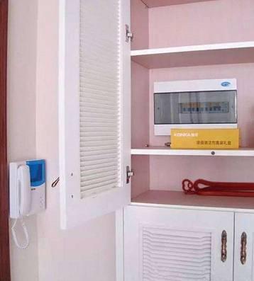 老電工把配電箱安裝在墻內。曬太陽太聰明了。